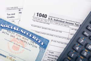 Tax return documents: Form 1040 - U.S. individual income tax return form and Social Security number card.