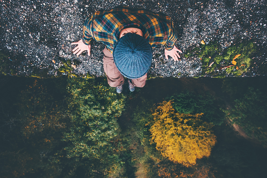 Man Sitting on Edge of Cliff